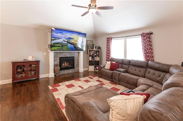 living room featuring ceiling fan, dark hardwood / wood-style flooring, lofted ceiling, and a tile fireplace