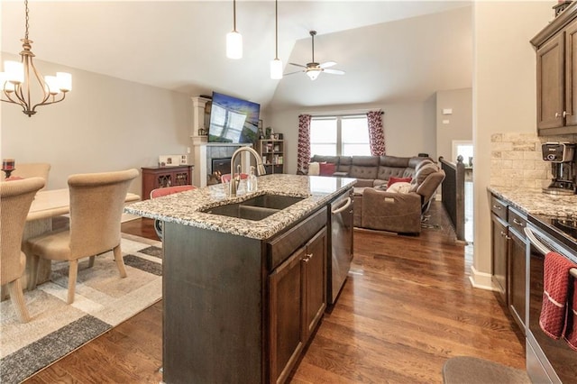 kitchen featuring backsplash, sink, an island with sink, stainless steel appliances, and light stone counters