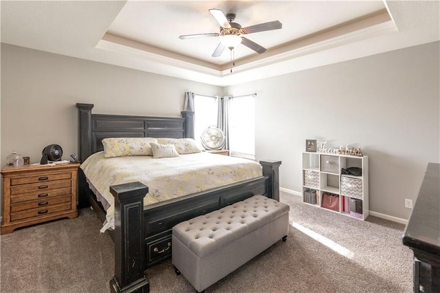 bedroom with ceiling fan, a raised ceiling, and dark colored carpet