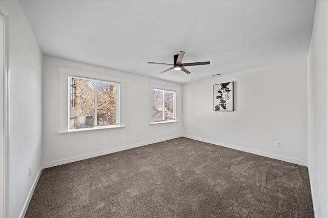 spare room with ceiling fan and dark colored carpet