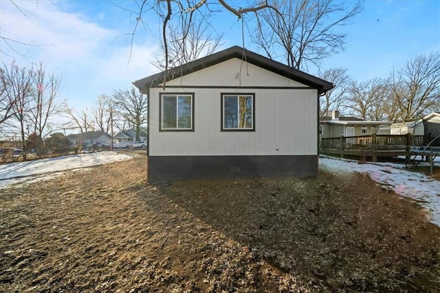 view of snowy exterior with a wooden deck