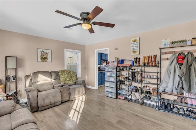 living room featuring ceiling fan and light wood-type flooring