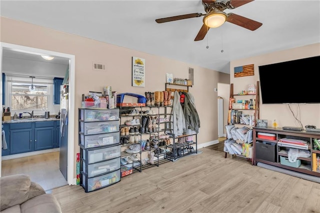 storage area featuring ceiling fan and sink