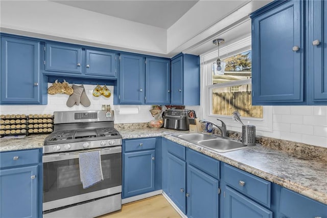 kitchen featuring blue cabinetry, sink, stainless steel gas range oven, light hardwood / wood-style floors, and decorative backsplash