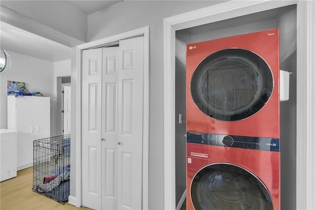 laundry room featuring wood-type flooring and stacked washer and clothes dryer