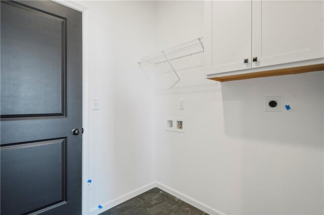 clothes washing area featuring dark tile patterned flooring, hookup for a washing machine, cabinets, and hookup for an electric dryer