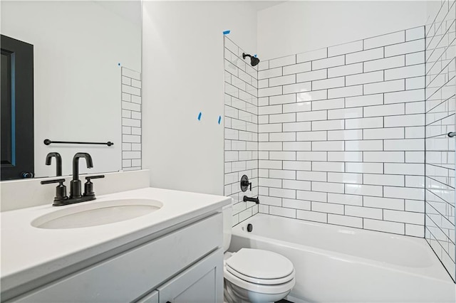 full bathroom featuring tiled shower / bath combo, vanity, and toilet