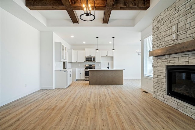 kitchen featuring coffered ceiling, white cabinets, pendant lighting, and appliances with stainless steel finishes