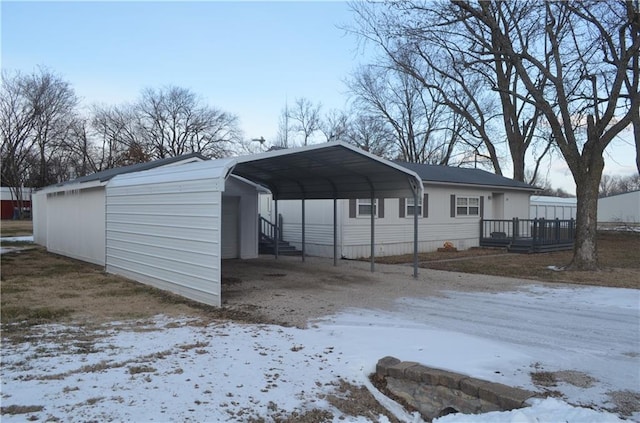 snow covered structure featuring a carport