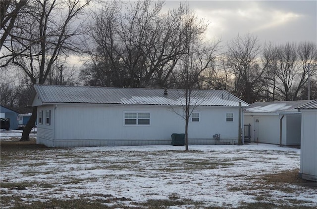 view of snow covered rear of property