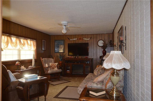 living room featuring ceiling fan, light colored carpet, and wooden walls