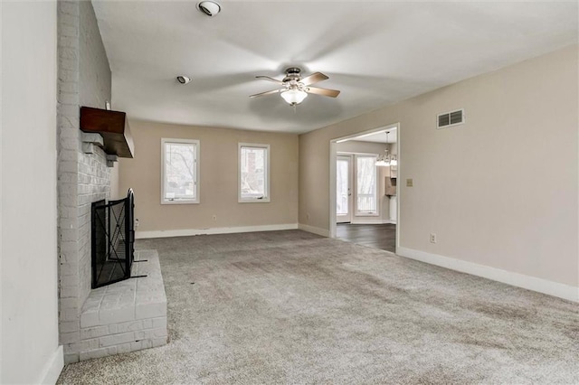 unfurnished living room featuring ceiling fan, a fireplace, carpet flooring, visible vents, and baseboards