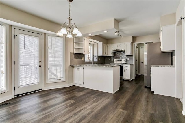 kitchen featuring under cabinet range hood, a peninsula, white cabinetry, hanging light fixtures, and stainless steel range with electric stovetop