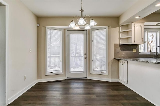 interior space featuring decorative light fixtures, open shelves, decorative backsplash, dark wood-type flooring, and white cabinets