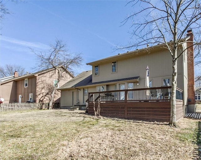 back of house featuring a chimney, fence, a lawn, and a wooden deck