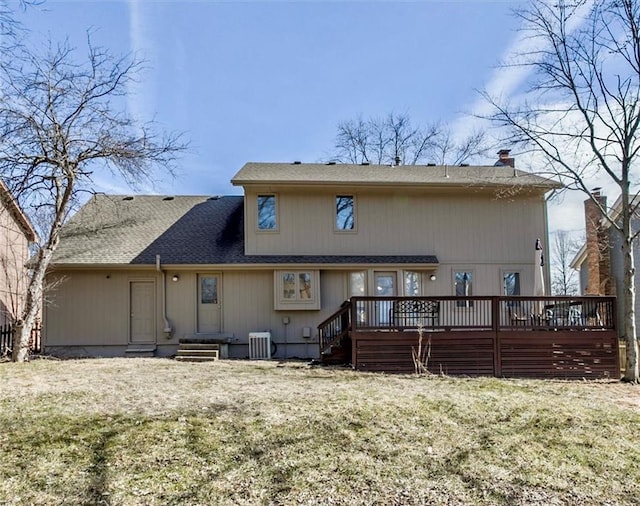 rear view of property with central AC unit, a deck, and a yard