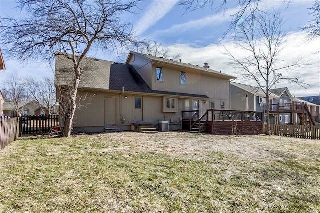 rear view of property with central air condition unit, fence private yard, a yard, and a wooden deck