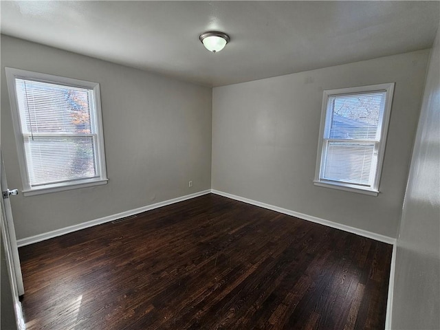 spare room with dark hardwood / wood-style flooring