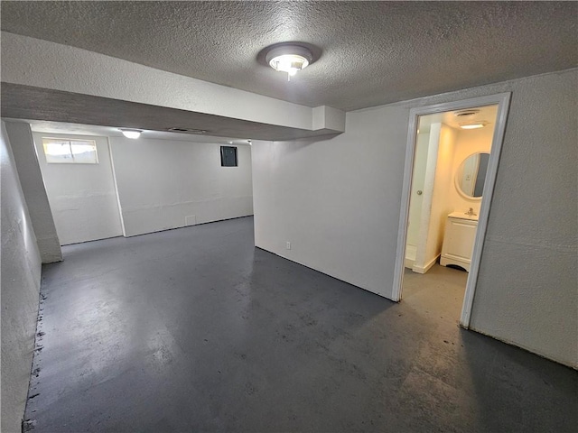 basement with a textured ceiling and sink