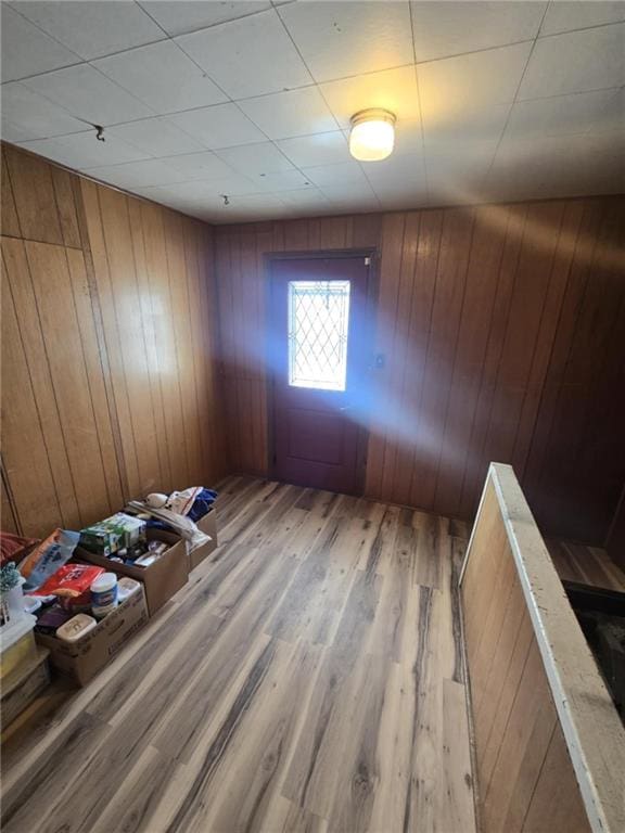 spare room with light hardwood / wood-style flooring and wooden walls