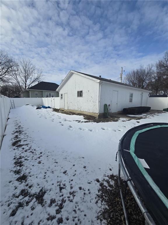 view of snow covered exterior with a trampoline