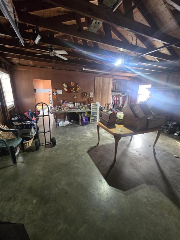 interior space with a wealth of natural light, lofted ceiling, wood walls, and concrete floors