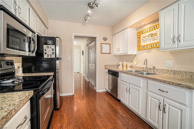 kitchen with sink, dark wood-type flooring, white cabinetry, stainless steel appliances, and a textured ceiling