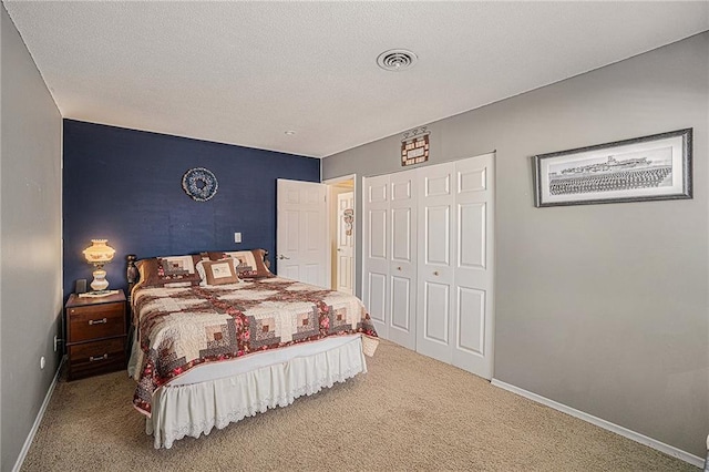 carpeted bedroom with a closet and a textured ceiling