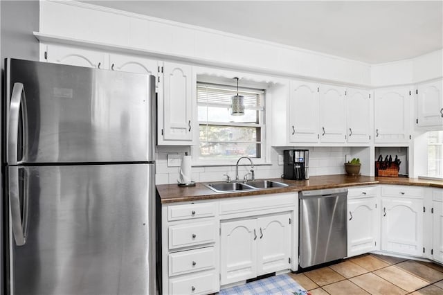 kitchen featuring decorative backsplash, appliances with stainless steel finishes, sink, and white cabinetry