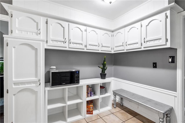 laundry room with light tile patterned floors and crown molding