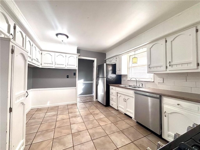 kitchen featuring light tile patterned floors, stainless steel appliances, white cabinets, and sink