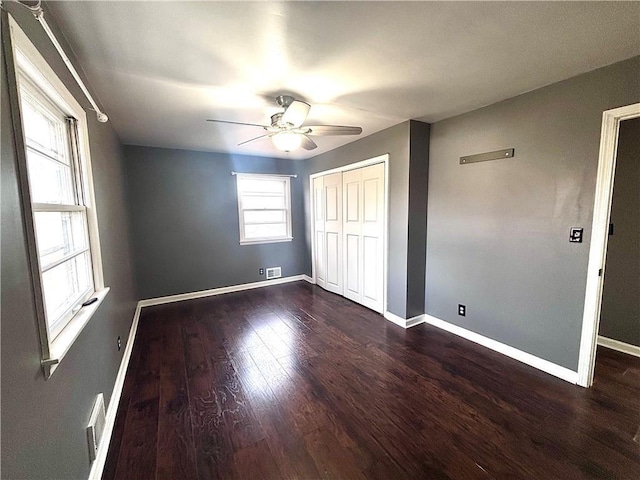 unfurnished bedroom with ceiling fan, dark hardwood / wood-style floors, and a closet