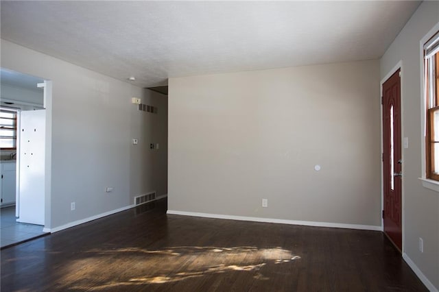 unfurnished room featuring dark wood-type flooring