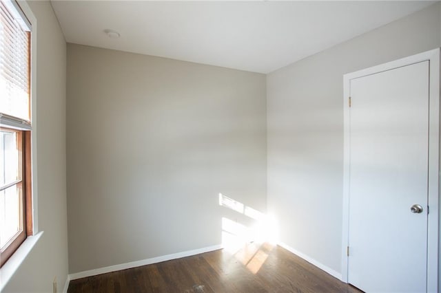 unfurnished room with dark wood-type flooring