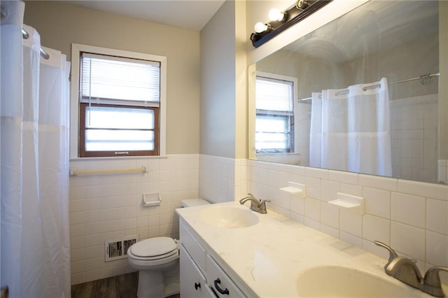 bathroom featuring toilet, tile walls, hardwood / wood-style flooring, and vanity