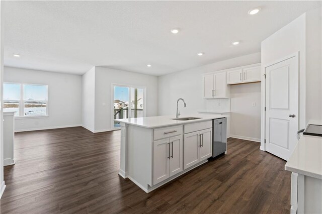 kitchen featuring white cabinetry, sink, dark hardwood / wood-style flooring, stainless steel dishwasher, and a center island with sink