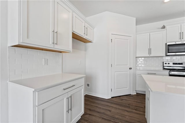 kitchen featuring tasteful backsplash, dark wood-type flooring, range, and white cabinets