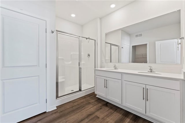 bathroom featuring a shower with door, wood-type flooring, and vanity