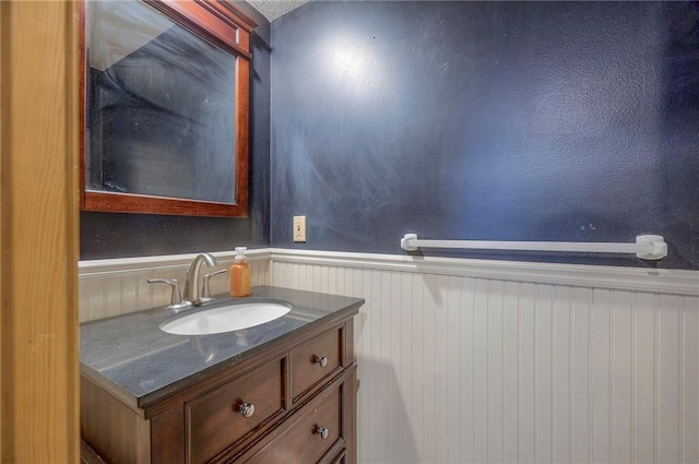 bathroom featuring wooden walls and vanity