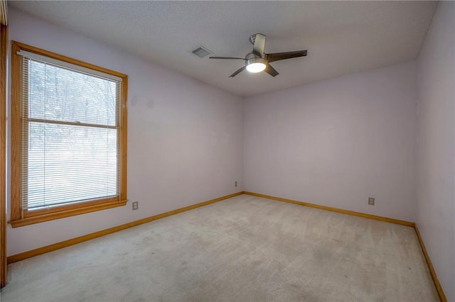 spare room featuring ceiling fan and light colored carpet