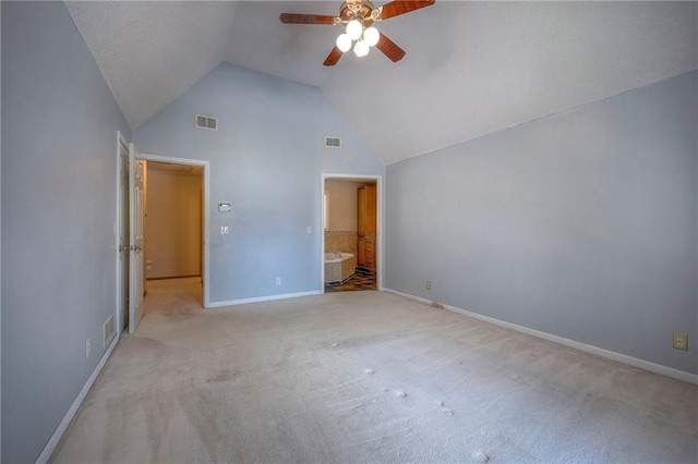 unfurnished bedroom featuring ceiling fan, connected bathroom, light colored carpet, and vaulted ceiling