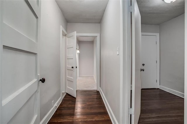 hall featuring dark hardwood / wood-style floors and a textured ceiling