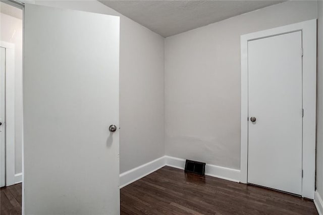 empty room with dark wood-type flooring