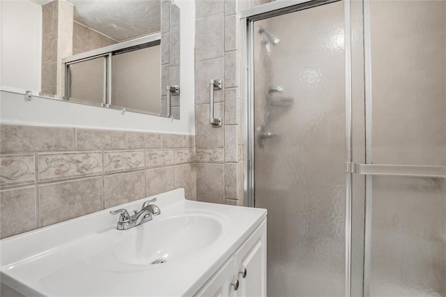 bathroom with tile walls, a shower with door, and vanity