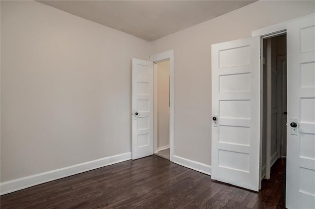 unfurnished bedroom with dark wood-type flooring