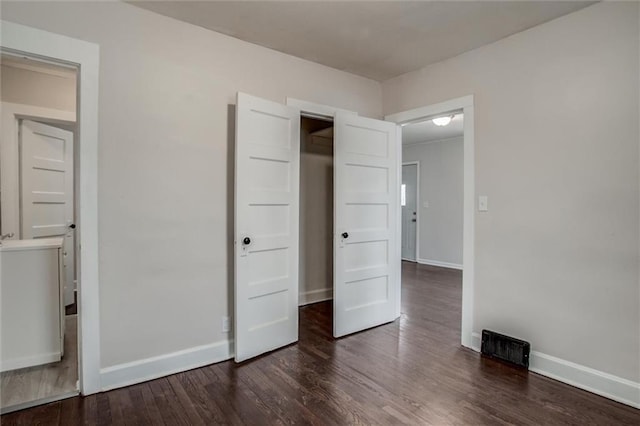 unfurnished bedroom with dark wood-type flooring