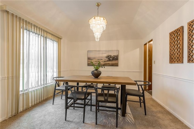 carpeted dining room featuring a chandelier