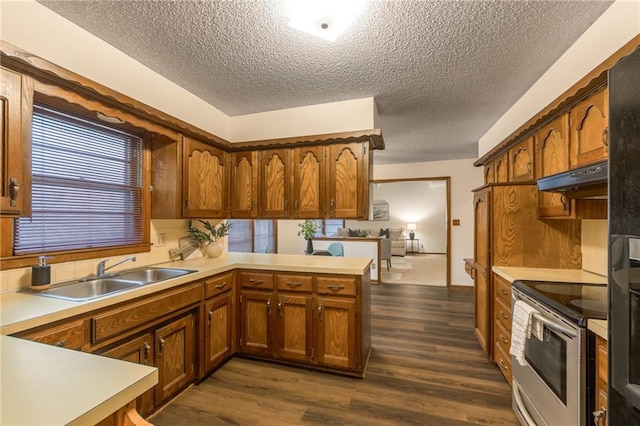 kitchen featuring dark hardwood / wood-style floors, sink, stainless steel range with electric stovetop, kitchen peninsula, and a textured ceiling