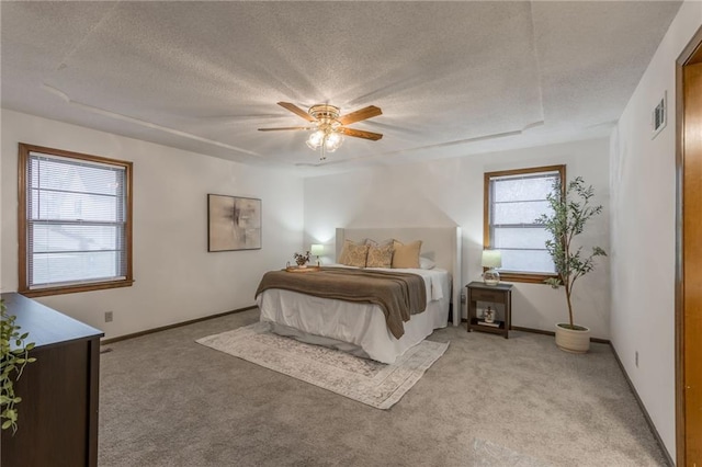 carpeted bedroom featuring ceiling fan and a textured ceiling