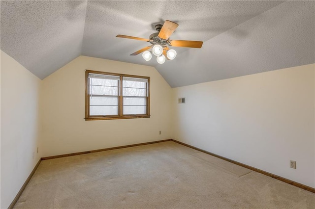 bonus room featuring ceiling fan, lofted ceiling, light carpet, and a textured ceiling